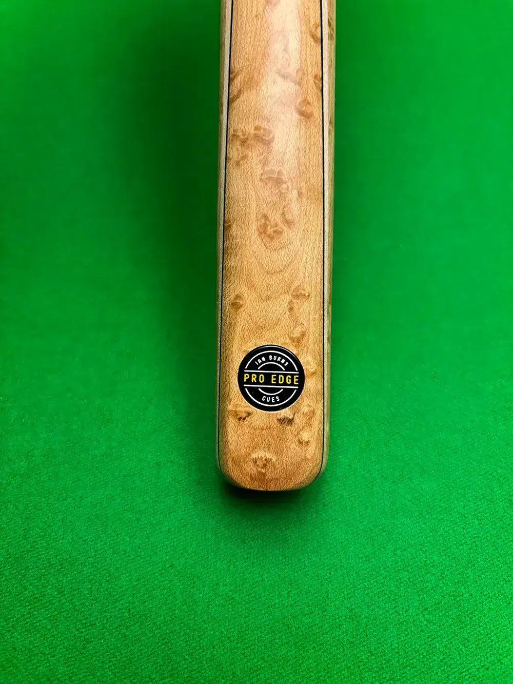 ash snooker cue with a pro edge cues logo on a snooker table