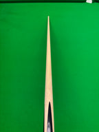 A close-up, top-down view of a wooden cue shaft pointing vertically down the center of a green snooker table.