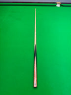 A single snooker cue laid vertically on a bright green snooker table, with the tip pointing upward and the butt near the bottom edge.