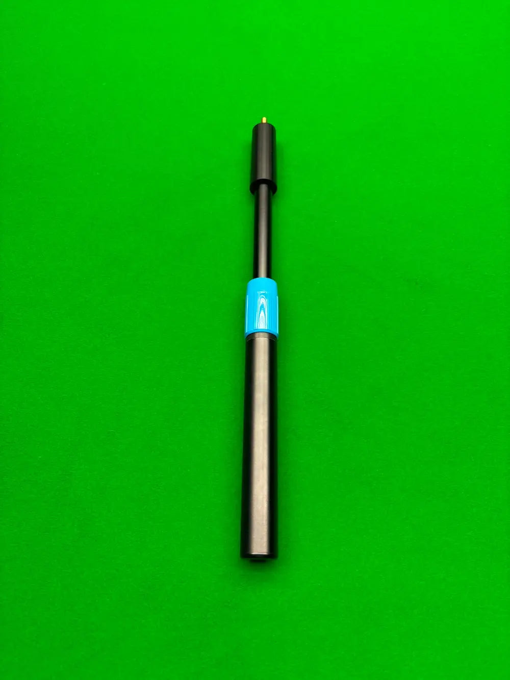 A black adjustable snooker cue extension with a bright blue accent band, positioned vertically on a solid green background.