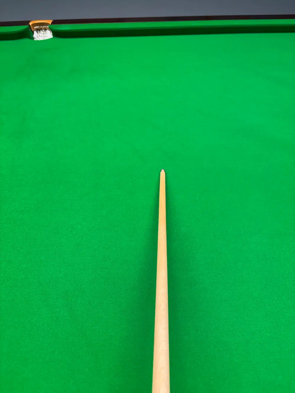maple snooker cue with a brass ferrule on a snooker table