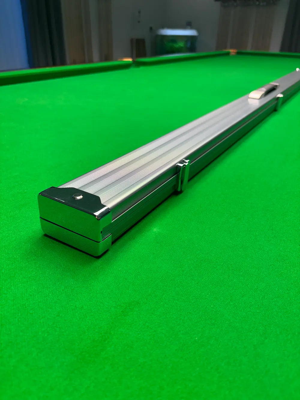 Snooker table with a silver snooker cue case on a green cloth