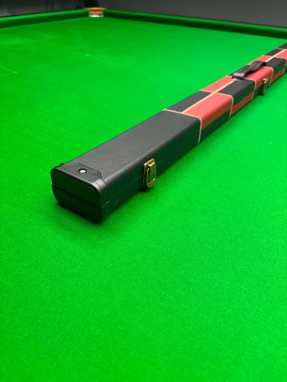 Snooker cue case with checkered wrap on a green snooker table