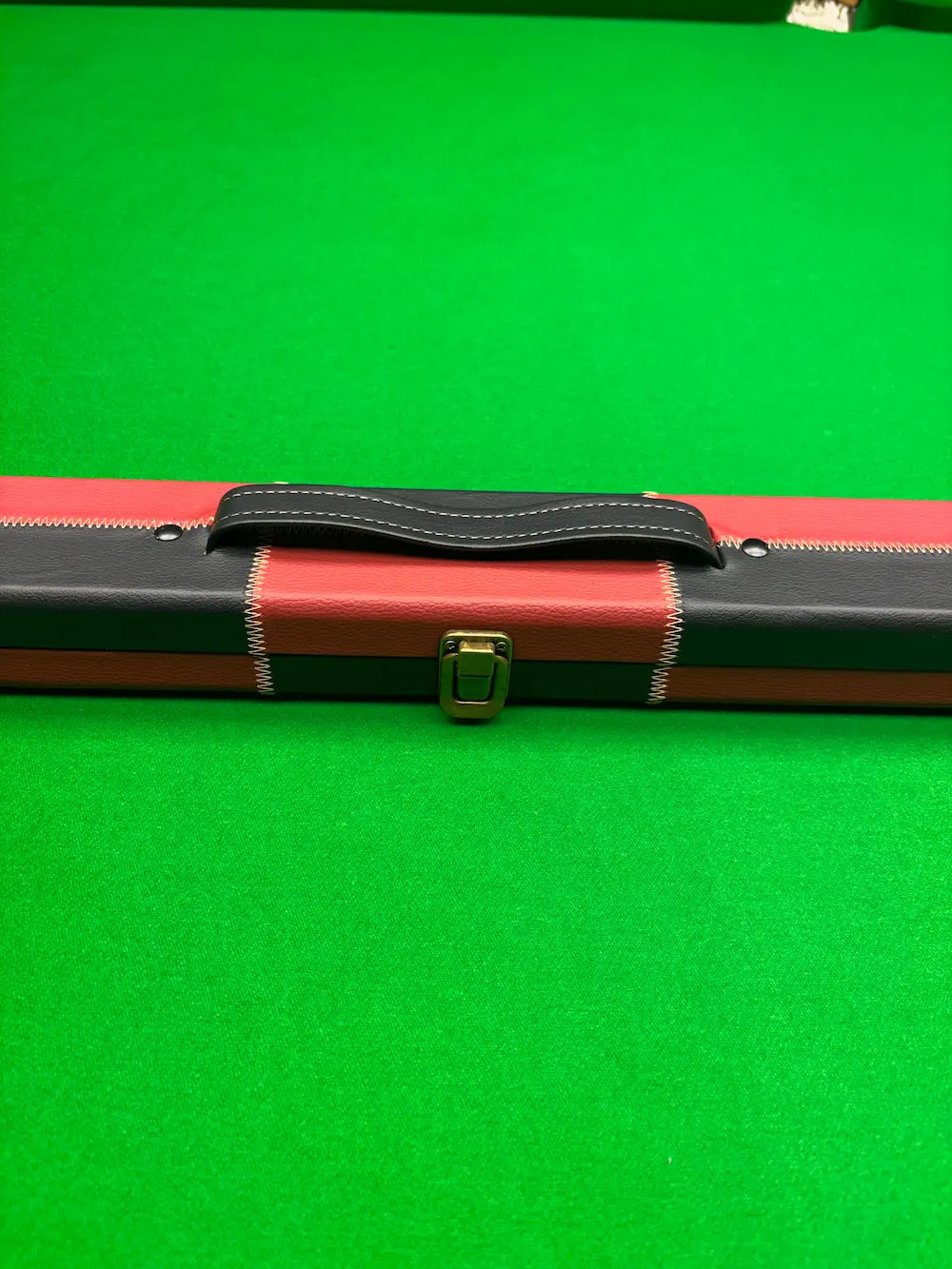 black and red snooker cue case on a snooker table