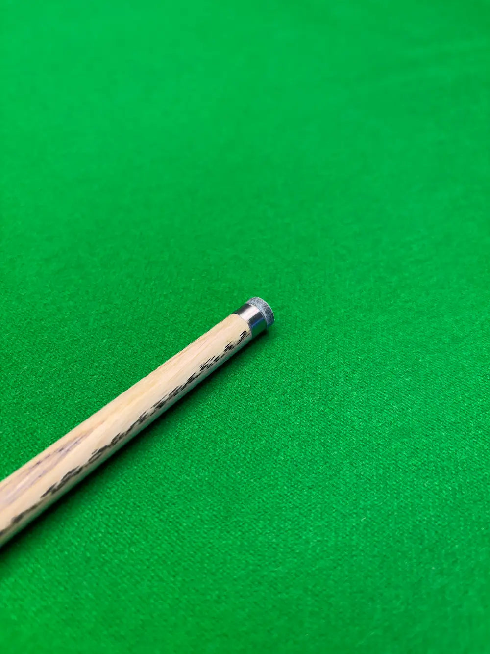 snooker cue with a titanium ferrule on a snooker table by pro edge snooker