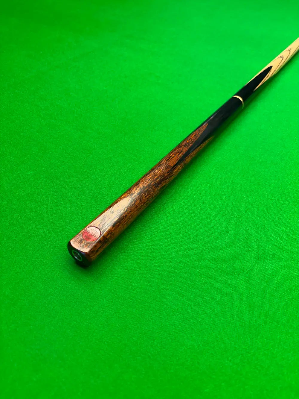 3/4 snooker cue with an Ebony and Lava Rosewood butt on a green snooker table