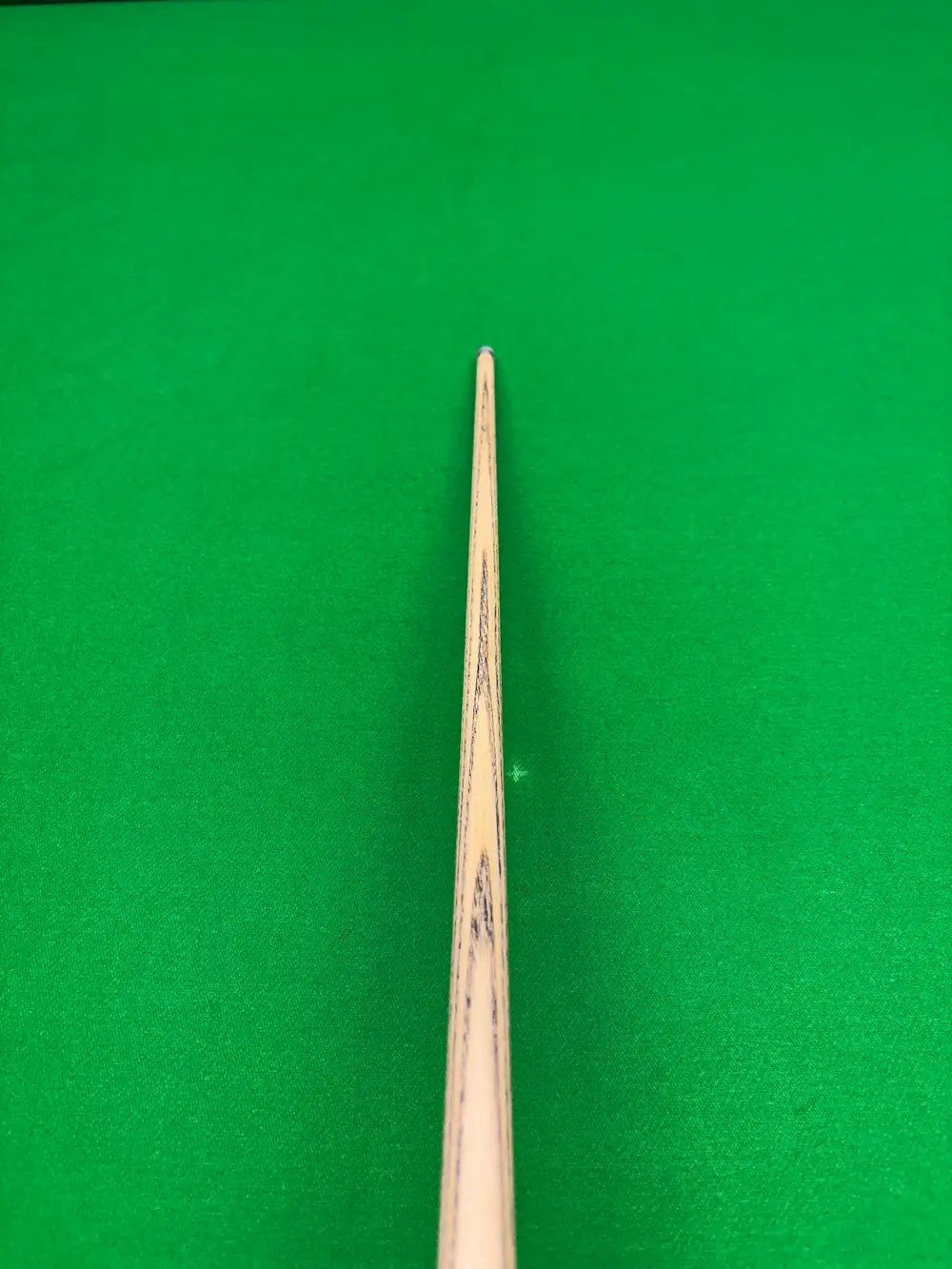 top view of an ash snooker cue on a snooker table