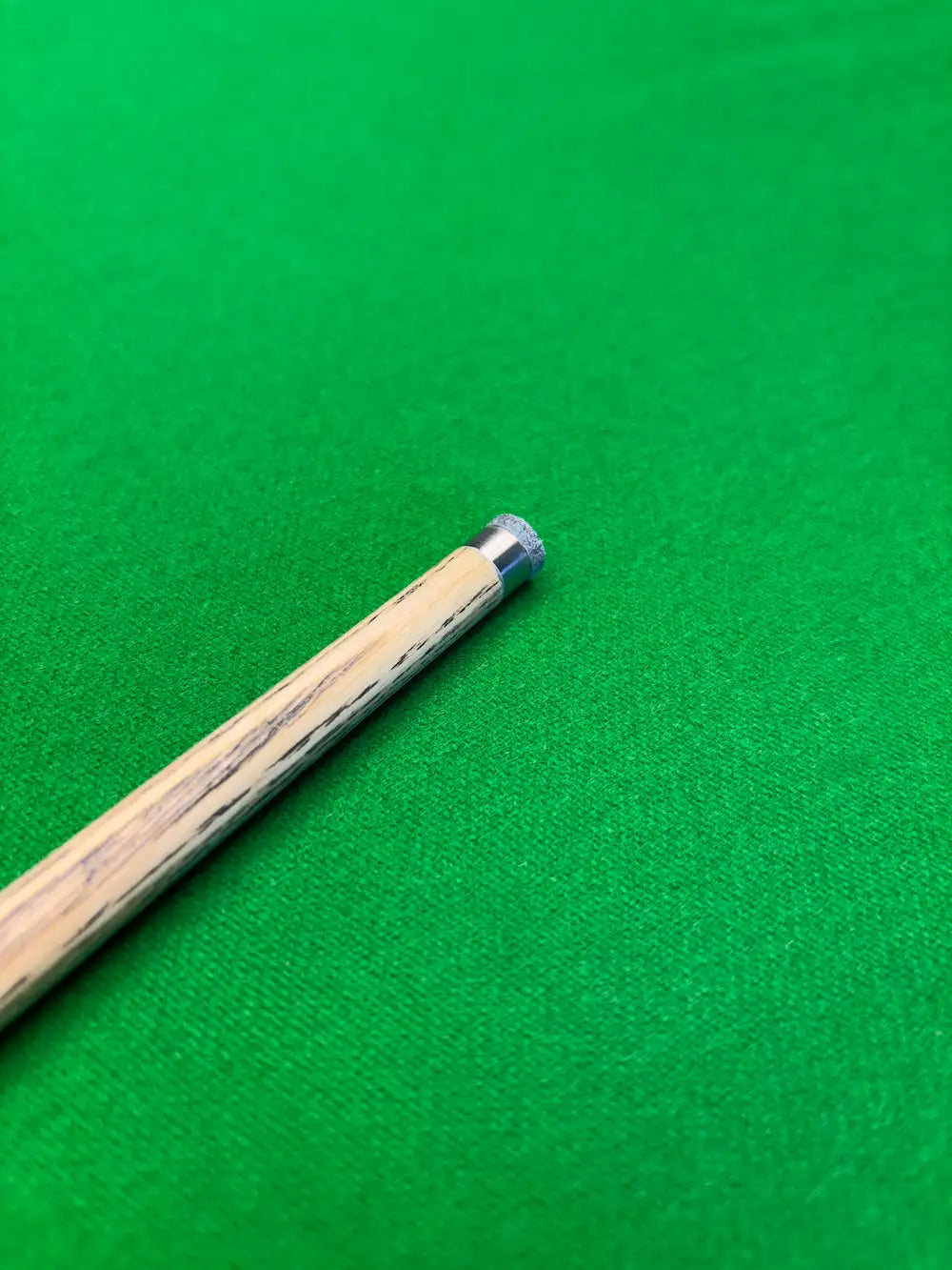 snooker cue with a titanium ferrule on a snooker table