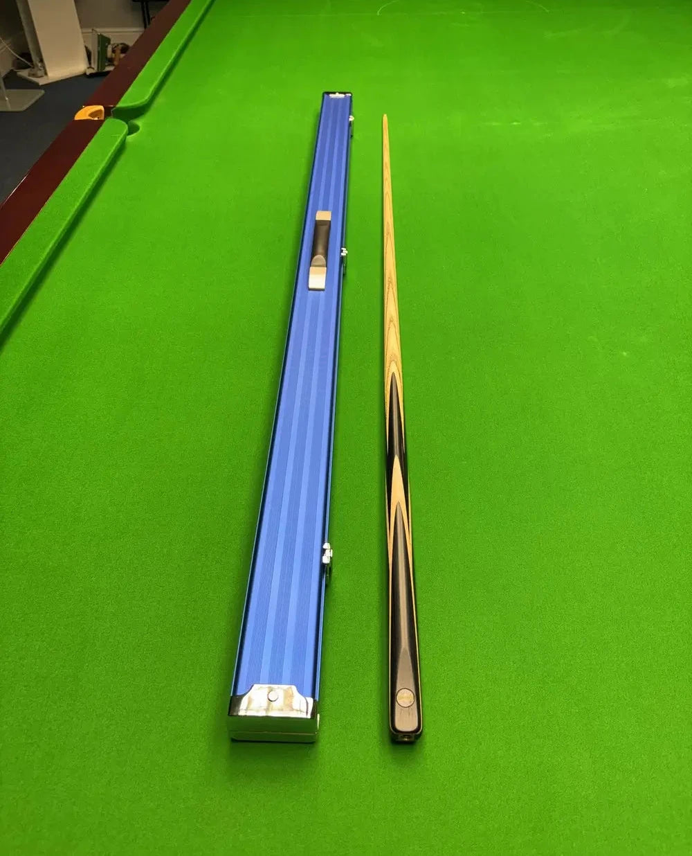 Pro Edge Precision Cue displayed alongside a sleek electric blue aluminium one‑piece cue case, highlighting professional craftsmanship and durable protection.