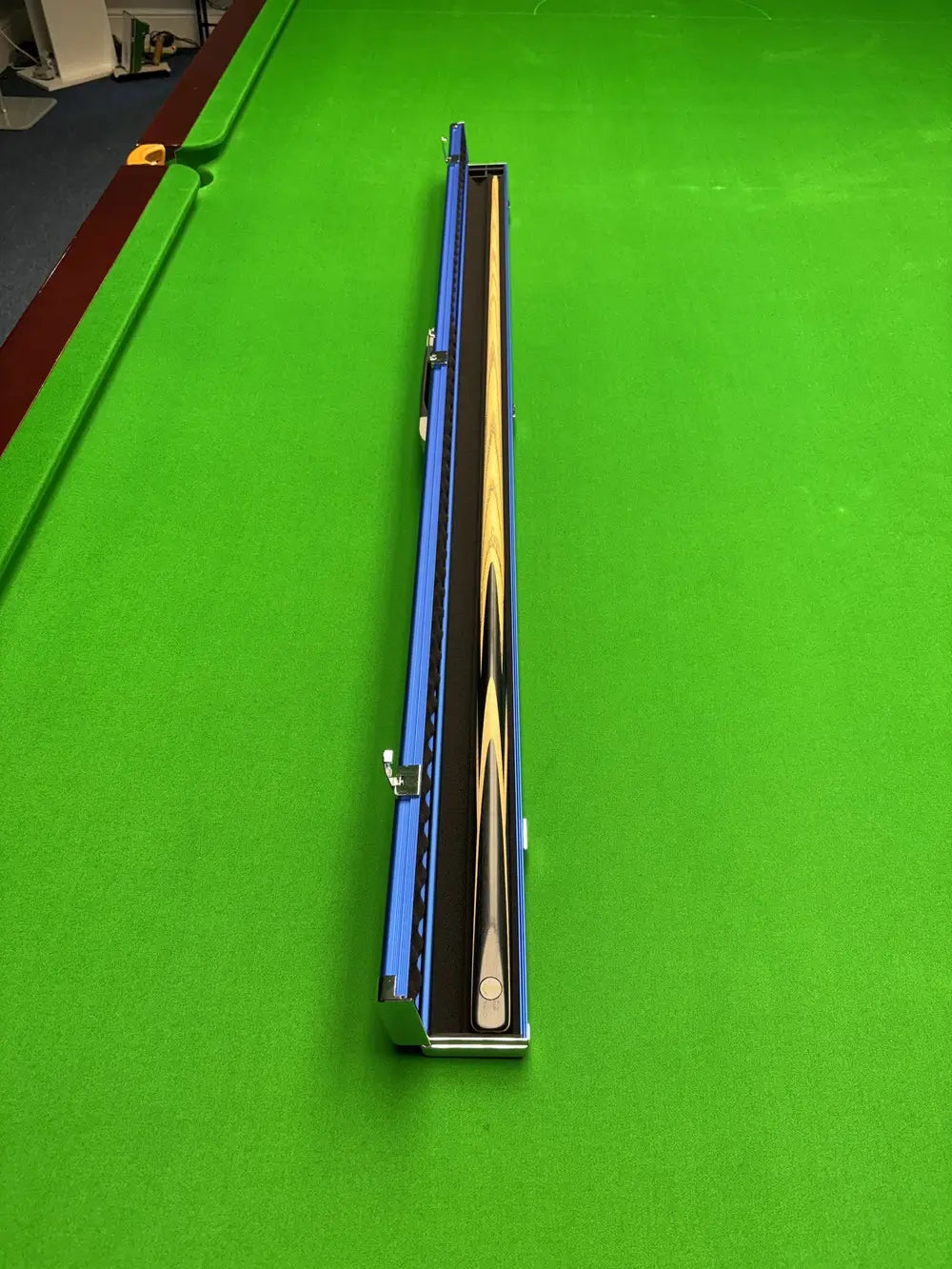 Pro Edge Precision Snooker Cue displayed alongside a sleek electric blue aluminium one‑piece cue case, highlighting professional craftsmanship and durable protection.