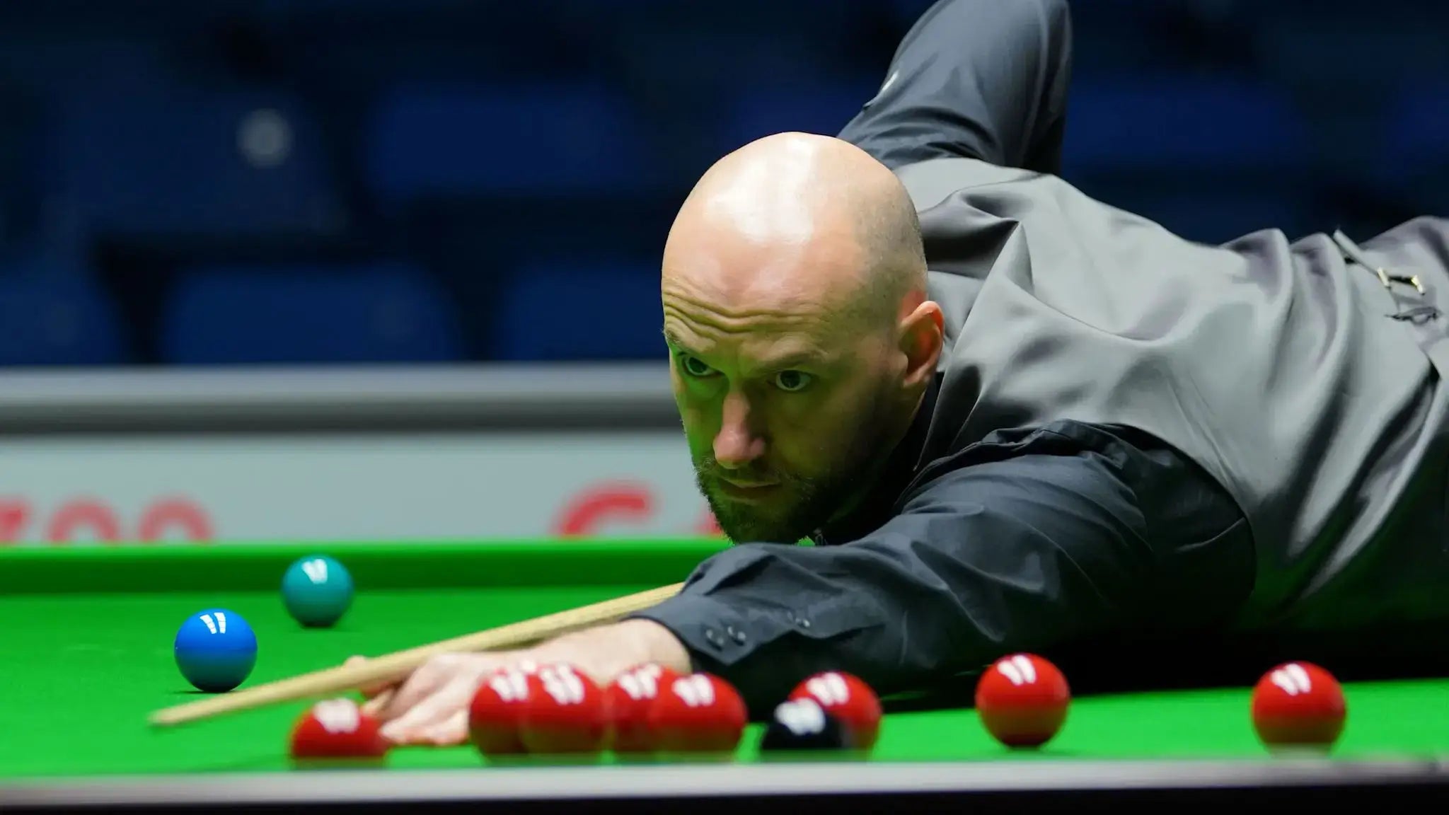 Snooker player Ian Burns taking a shot at a snooker table